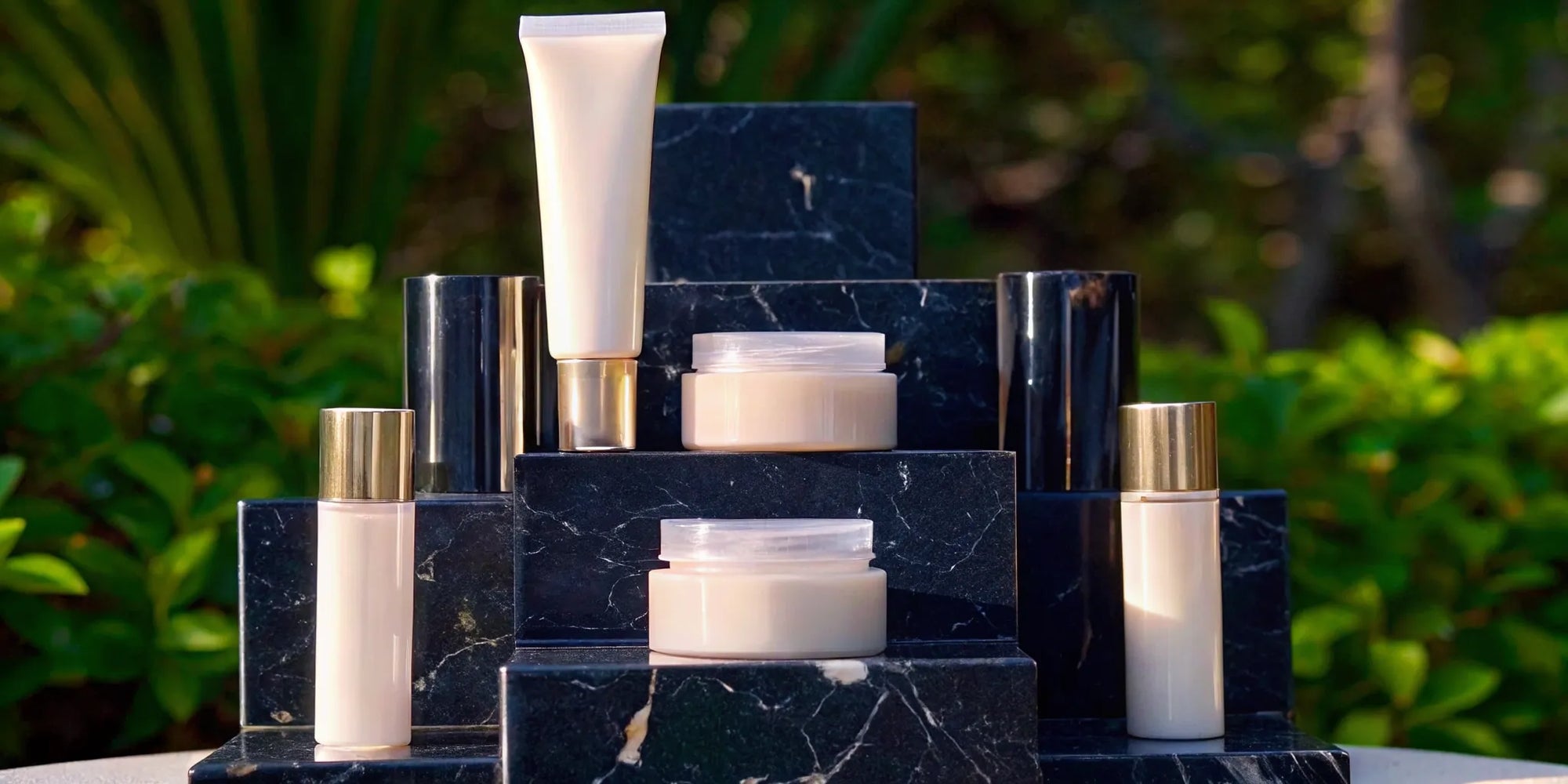 A collection of the best vegan luxury face creams displayed on a black marble surface.